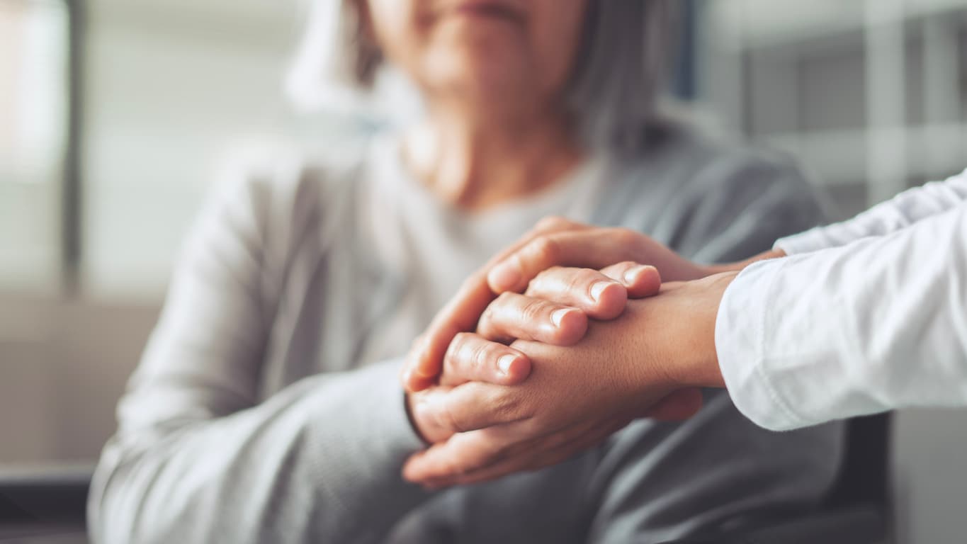 Hands holding an elderly woman's hands