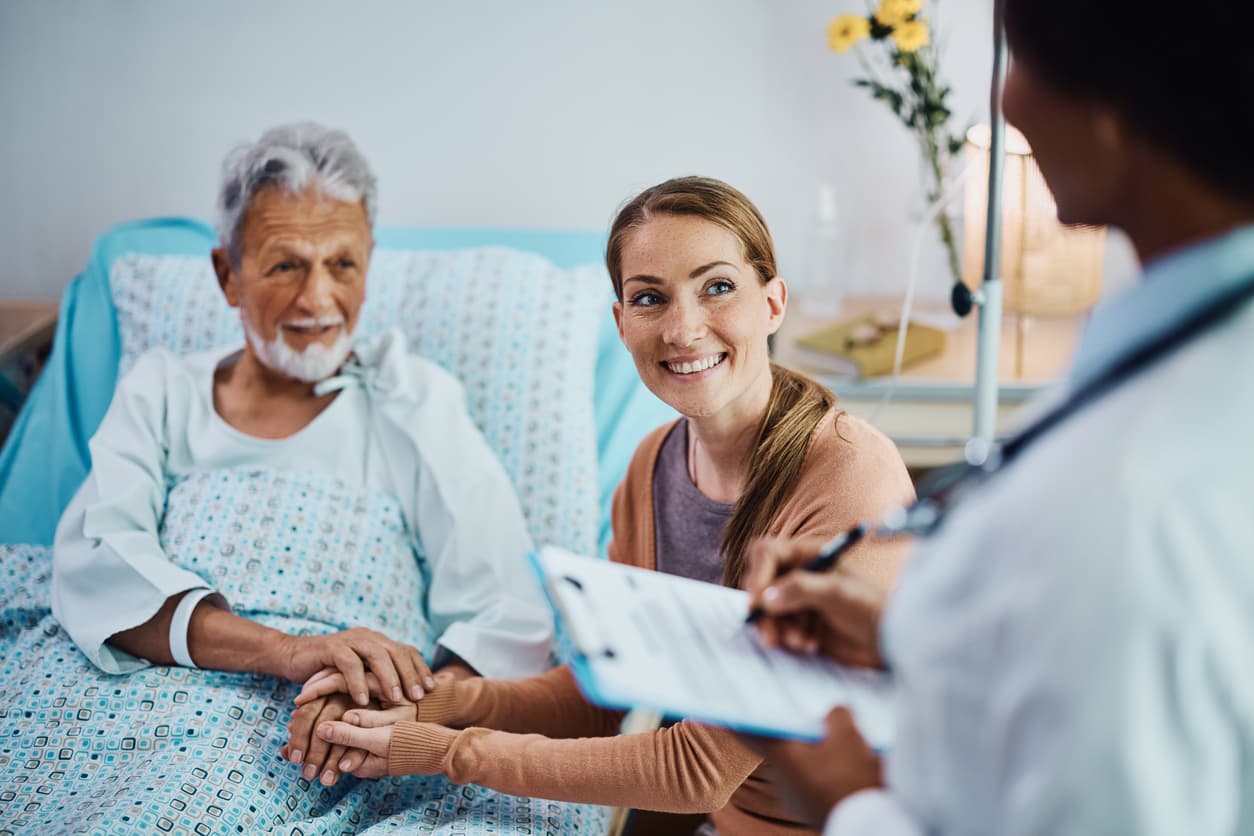 A woman and her hospitalized father talking with a doctor at the clinic
