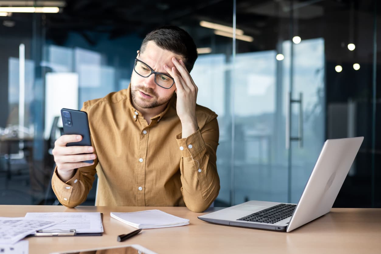 A worried businessman receiving bad news over the phone